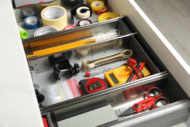 Set of instruments in open desk drawer indoors, closeup