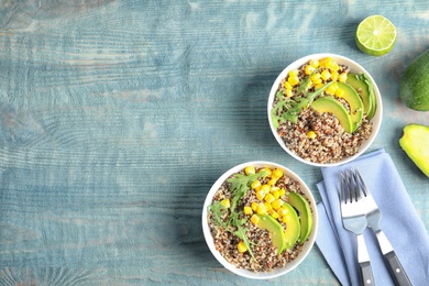 Photo of Healthy quinoa salad with vegetables in bowls served on wooden table, top view. Space for text