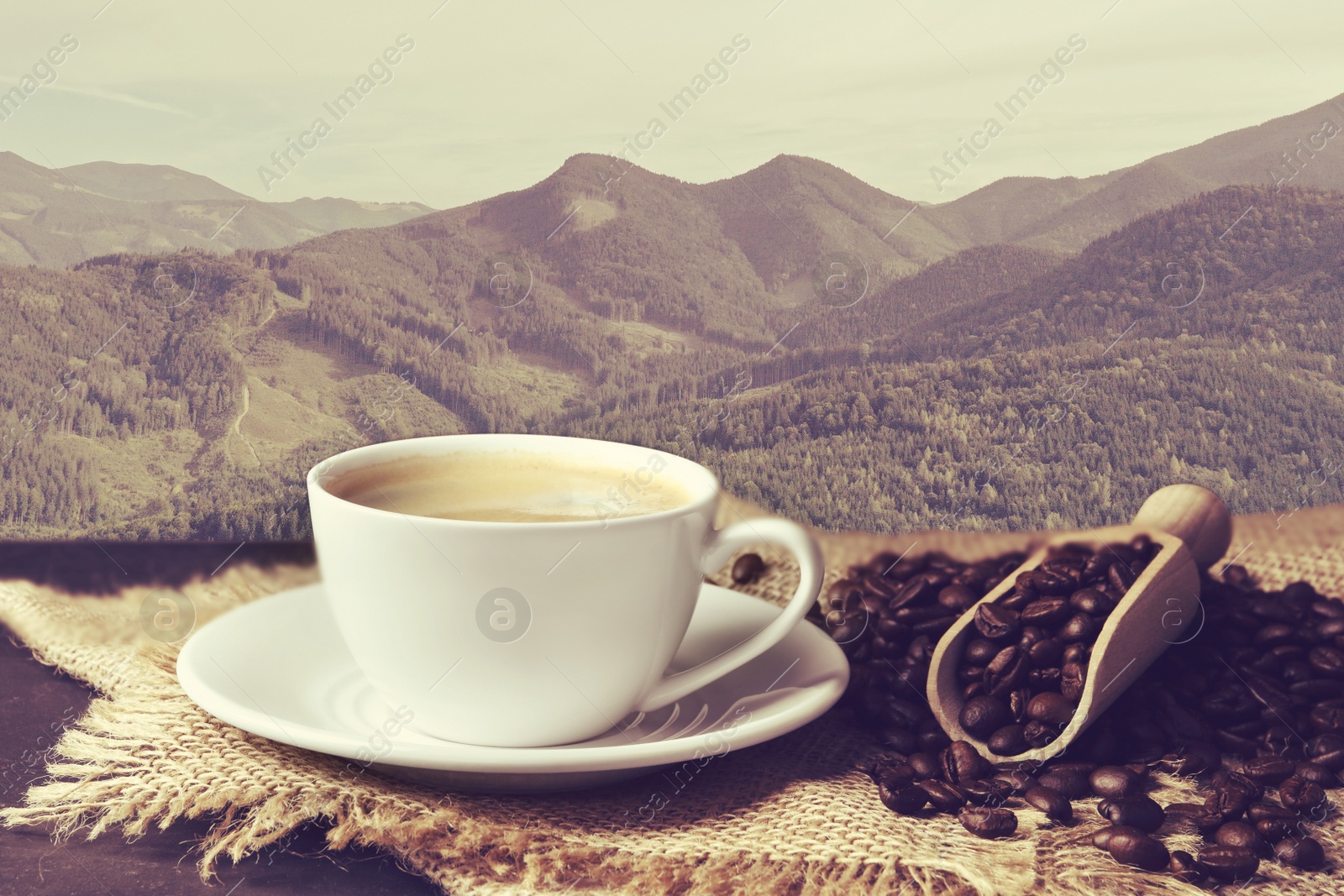 Image of Cup of aromatic hot coffee on wooden table and beautiful view of mountain landscape