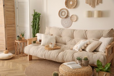 Stylish living room interior with comfortable wooden sofa and beautiful houseplants