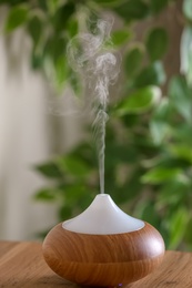 Photo of Aroma oil diffuser lamp on table against blurred background