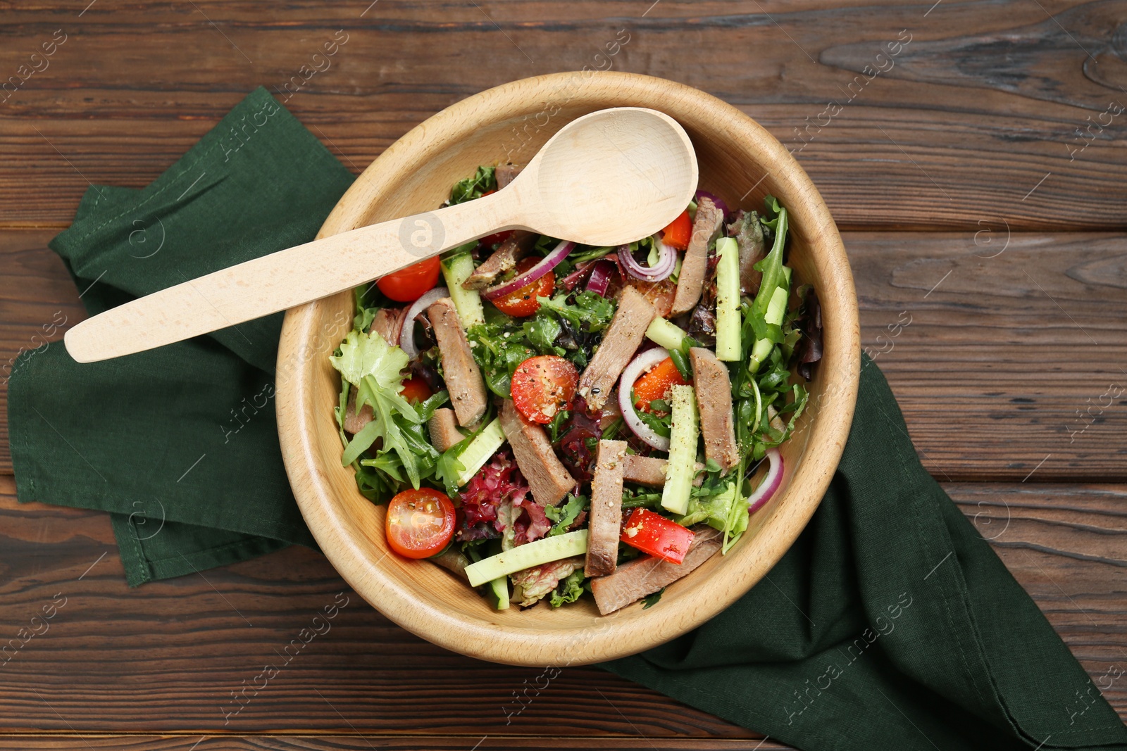 Photo of Delicious salad with beef tongue, vegetables and spoon served on wooden table, flat lay