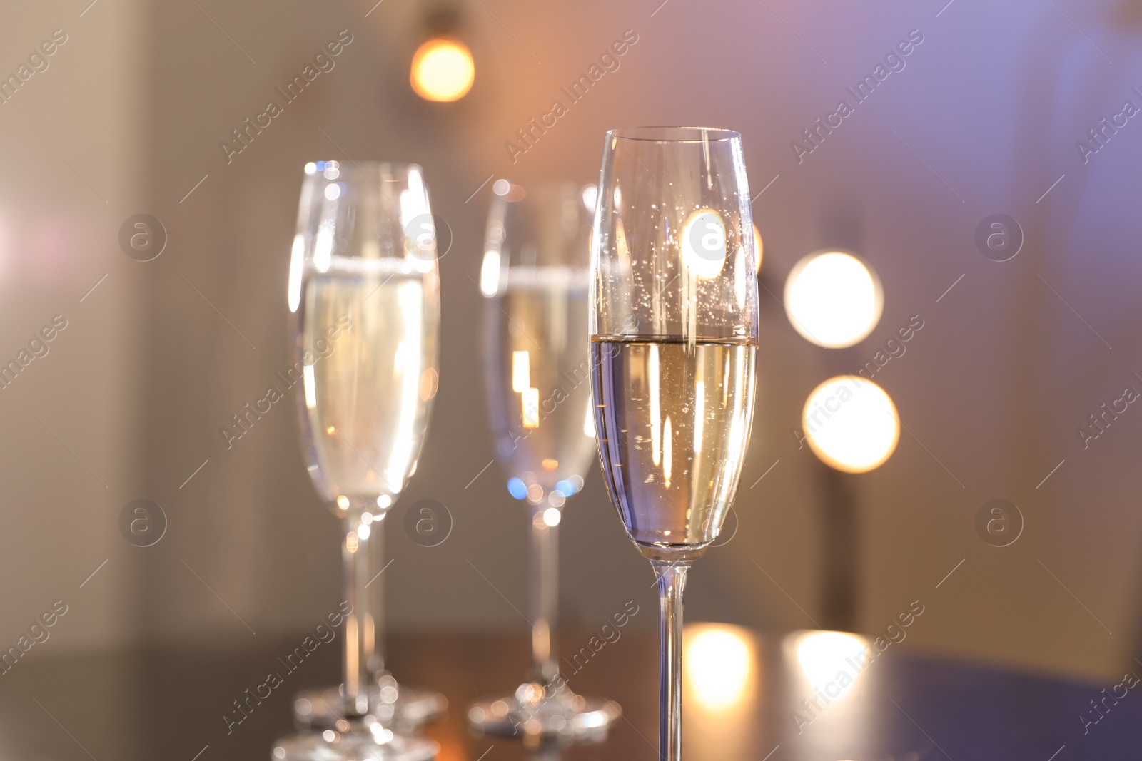 Photo of Glasses of champagne on blurred background, closeup. Space for text