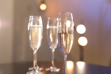 Photo of Glasses of champagne on blurred background, closeup. Space for text