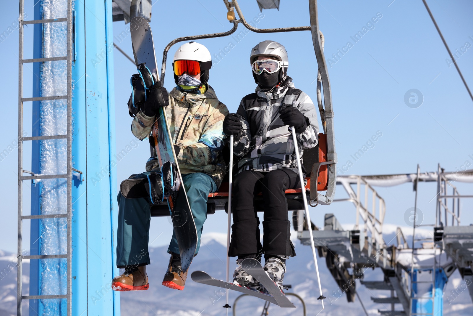 Photo of People using chairlift at mountain ski resort. Winter vacation