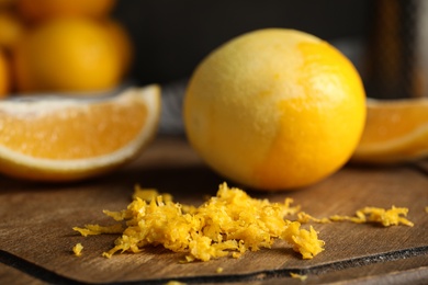 Lemon zest and fresh fruits on wooden board, closeup