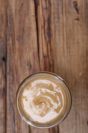 Photo of Tasty nut paste in jar on wooden table, top view. Space for text