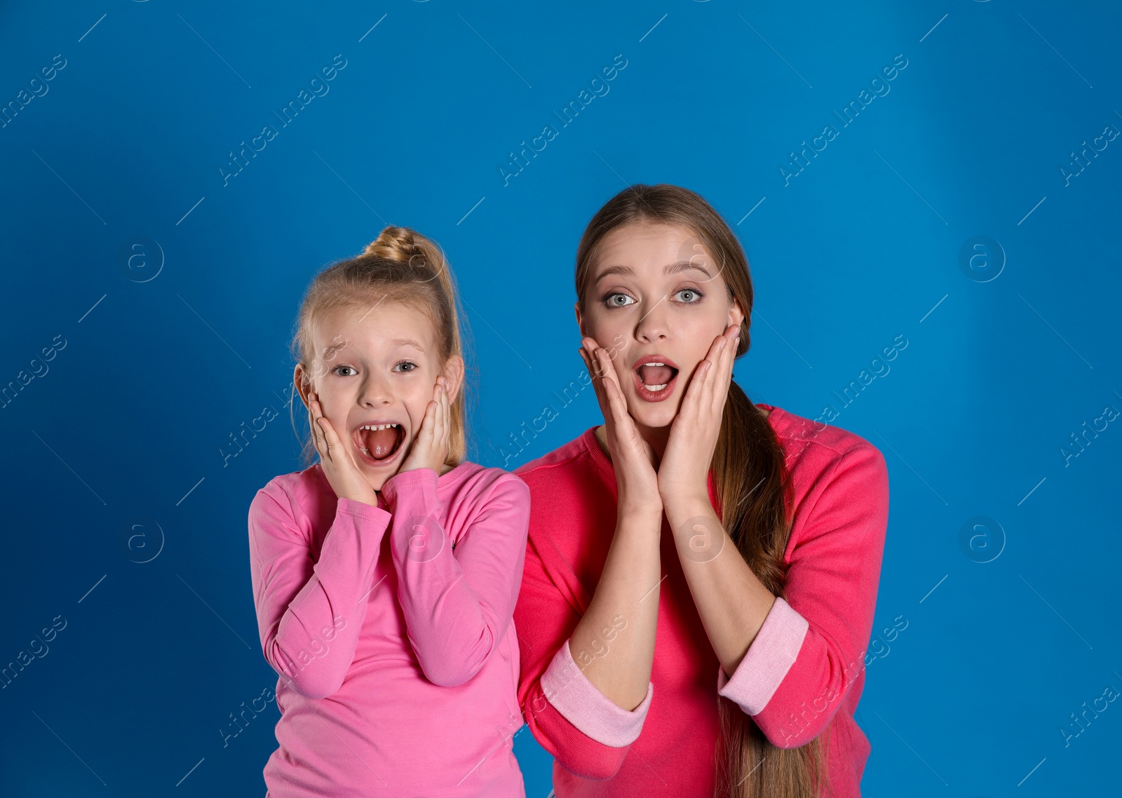 Photo of Emotional mother and daughter on blue background
