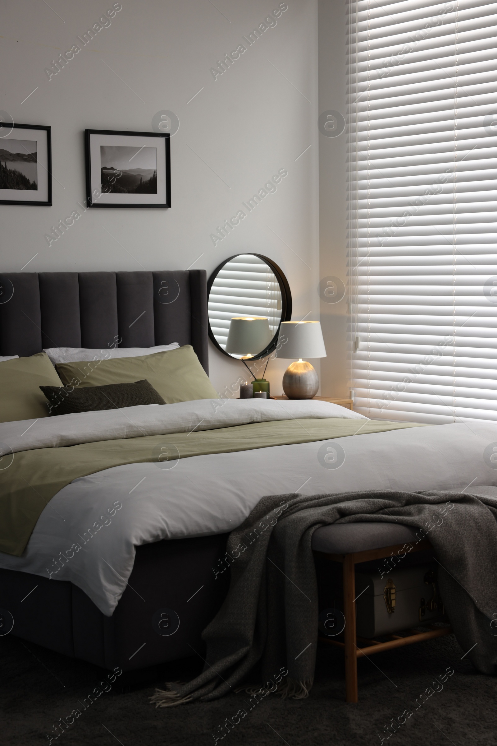 Photo of Window with horizontal blinds and comfortable bed in room