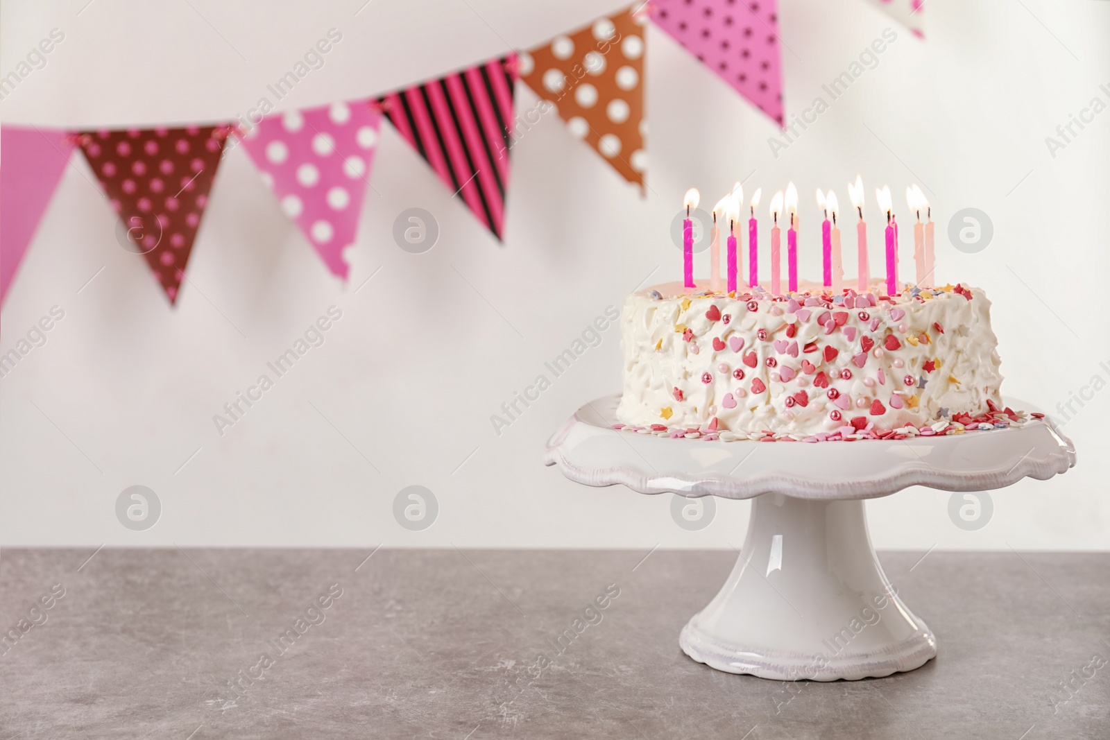 Photo of Birthday cake with candles on table against white background