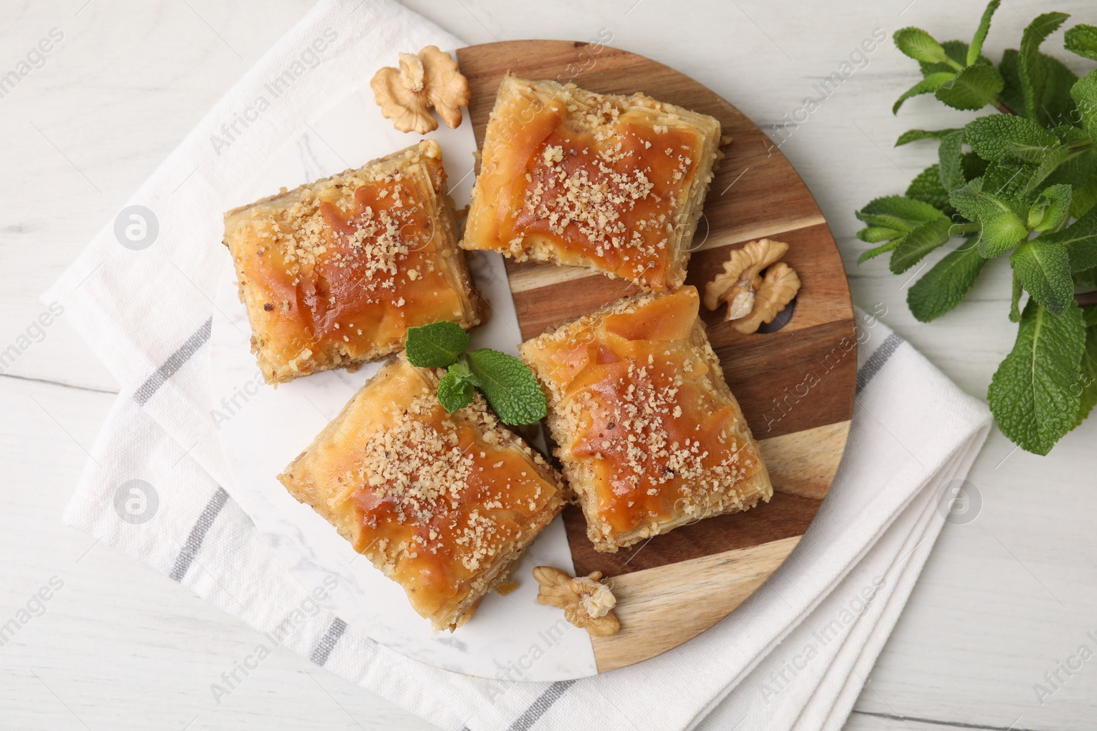 Photo of Eastern sweets. Pieces of tasty baklava on white wooden table, top view