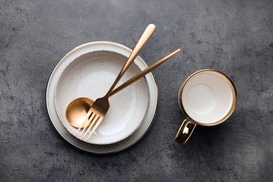 Photo of Stylish empty dishware and cutlery on grey table, flat lay