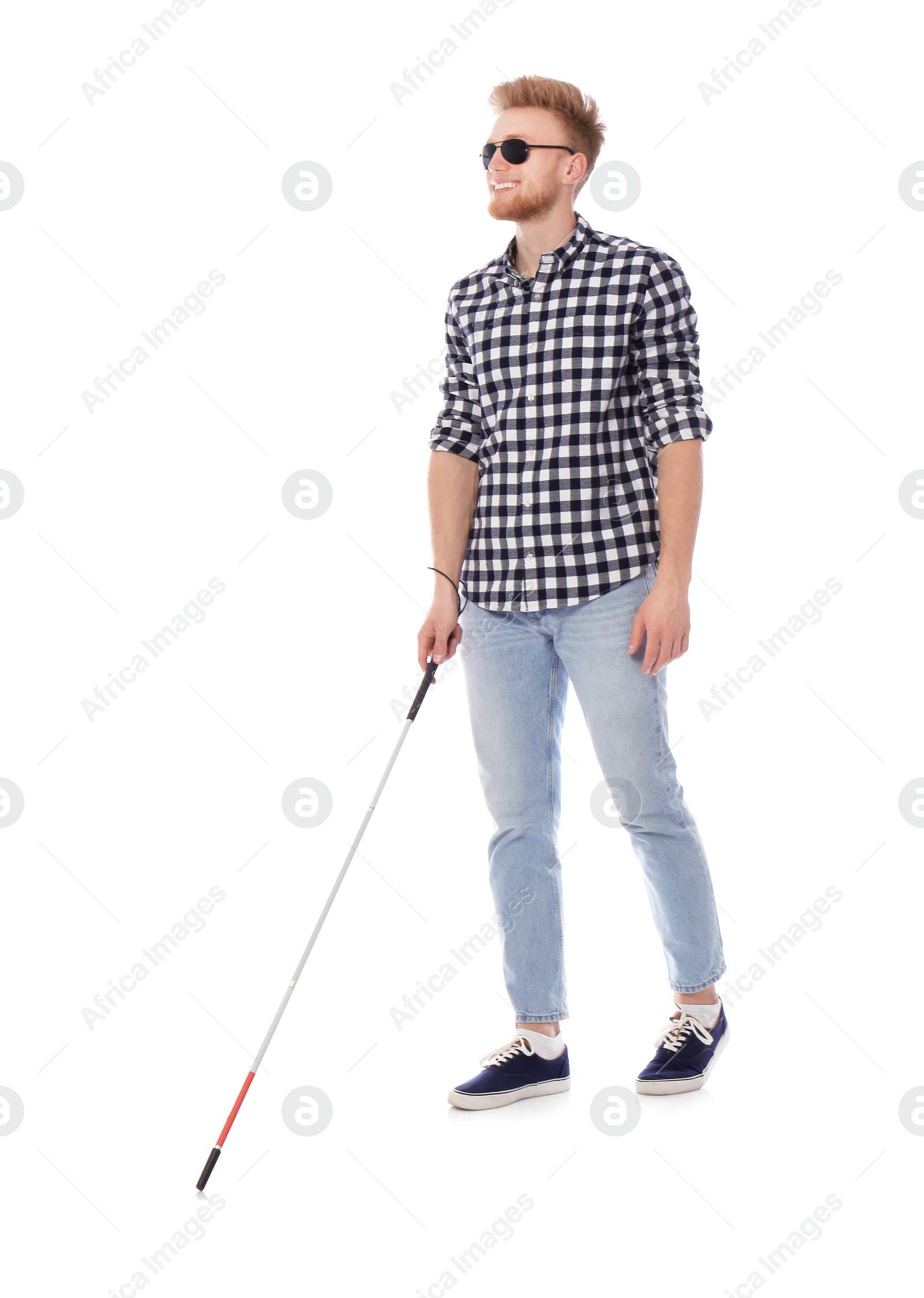 Photo of Young blind person with long cane walking on white background