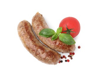 Photo of Tasty homemade sausages, peppercorns, tomato and basil leaves isolated on white, top view