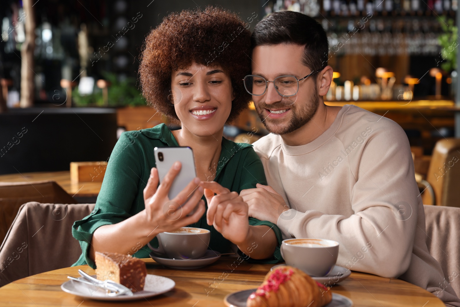 Photo of International dating. Lovely couple spending time together in cafe