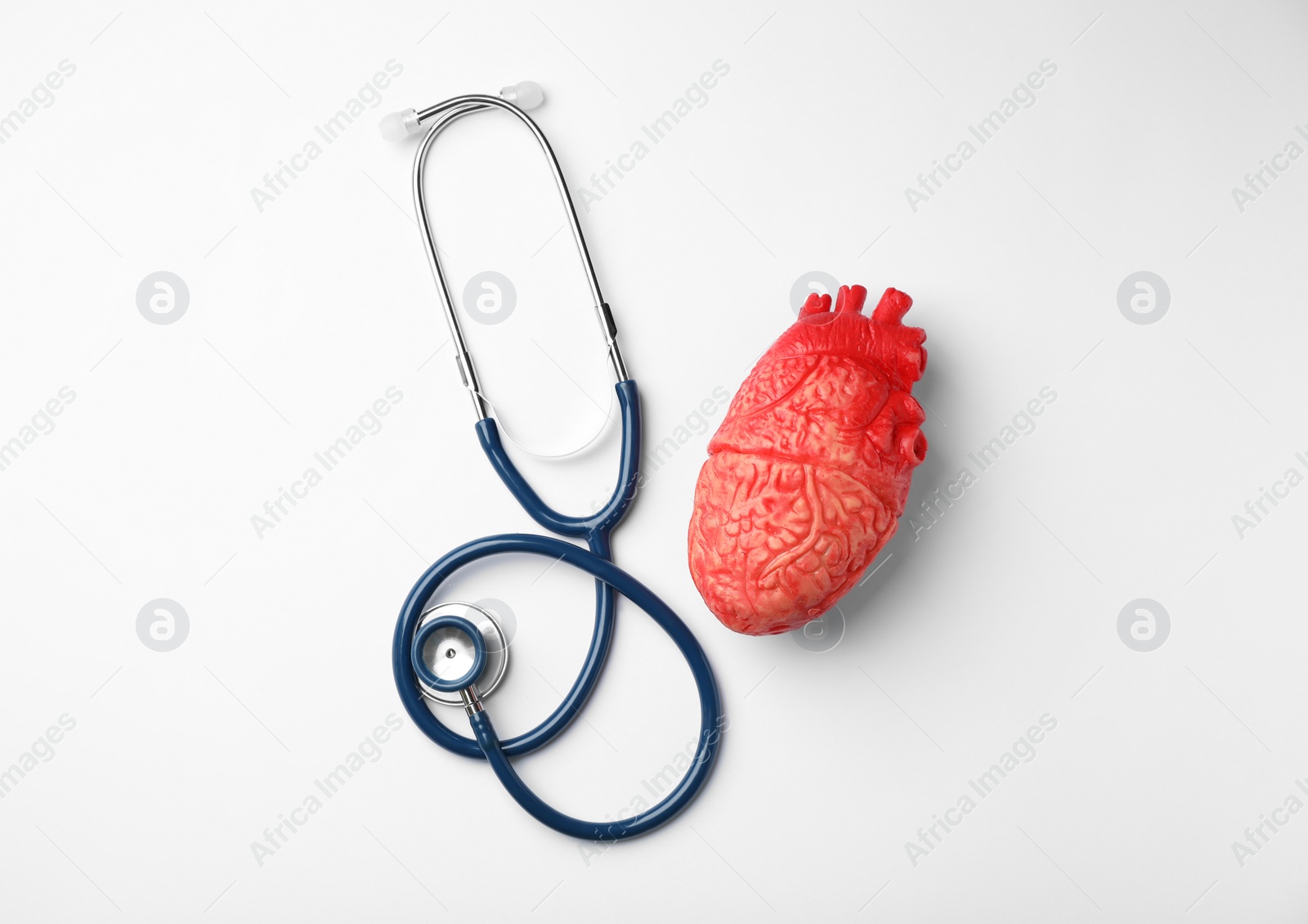 Photo of Stethoscope for checking pulse and heart model on white background, top view