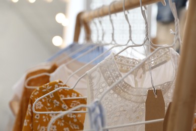 Photo of Rack with different new dresses in showroom