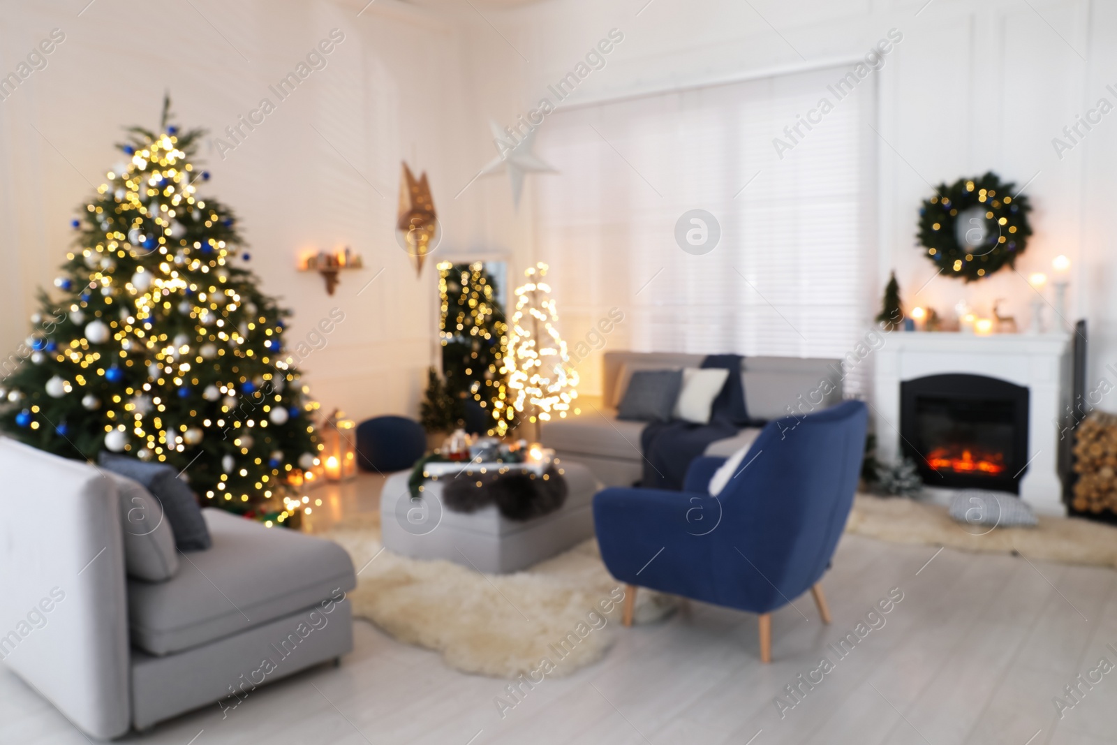 Photo of Blurred view of festively decorated room with Christmas tree and furniture