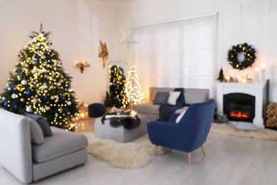 Photo of Blurred view of festively decorated room with Christmas tree and furniture