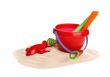 Set of plastic beach toys and pile of sand on white background