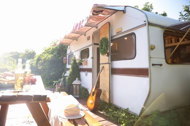 Guitar near modern trailer on sunny day. Camping season