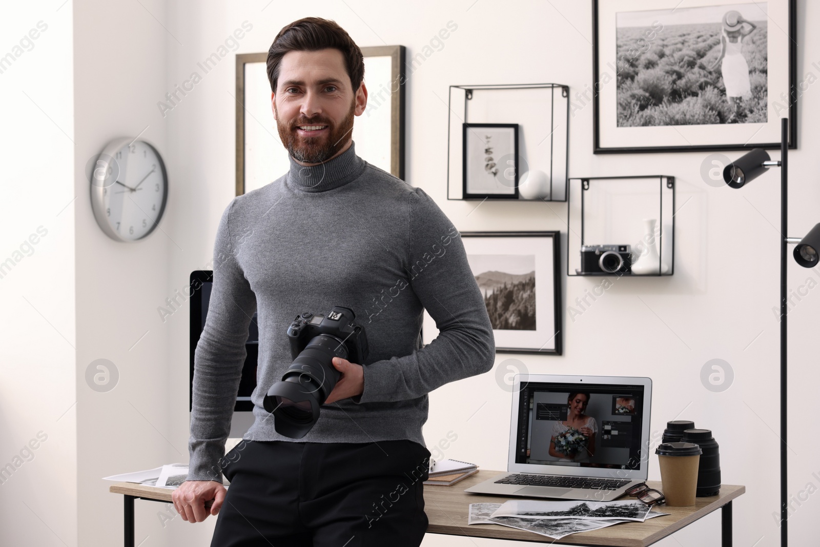 Photo of Professional photographer with digital camera near table in office