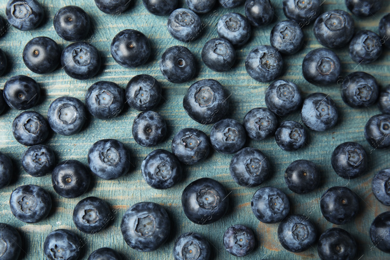 Photo of Fresh tasty blueberries on wooden table, flat lay