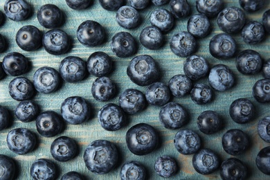 Photo of Fresh tasty blueberries on wooden table, flat lay