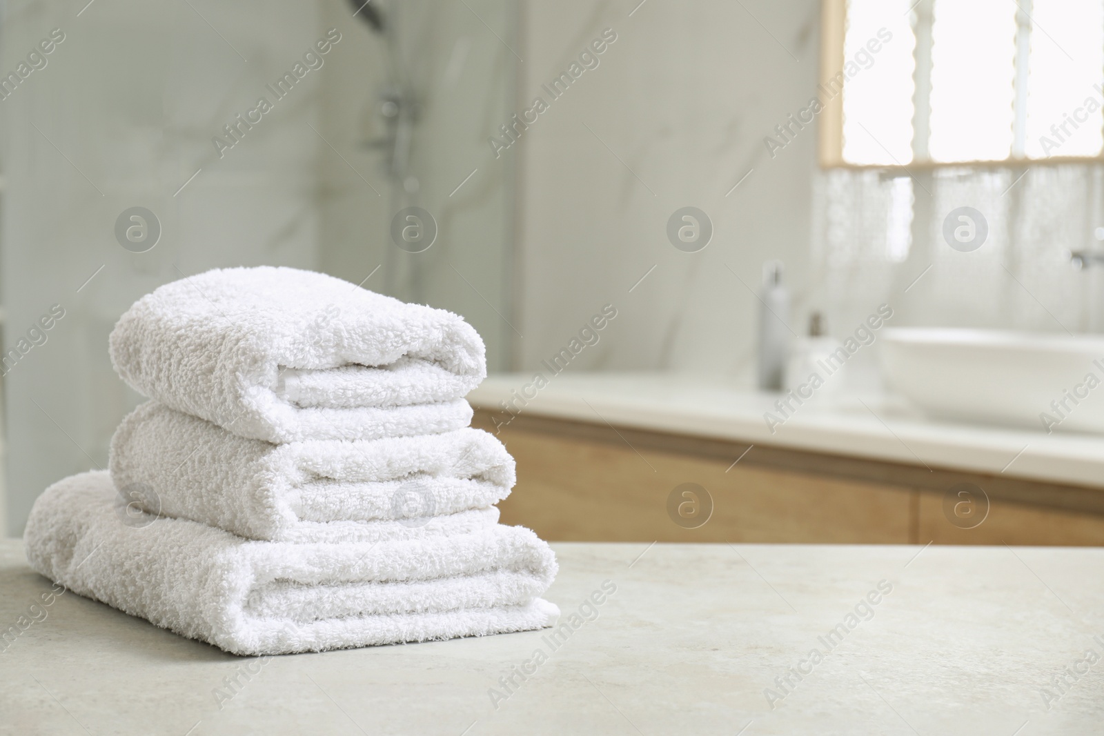 Photo of Stack of clean towels on table indoors. Space for text