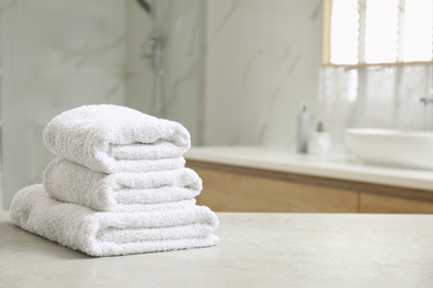 Photo of Stack of clean towels on table indoors. Space for text