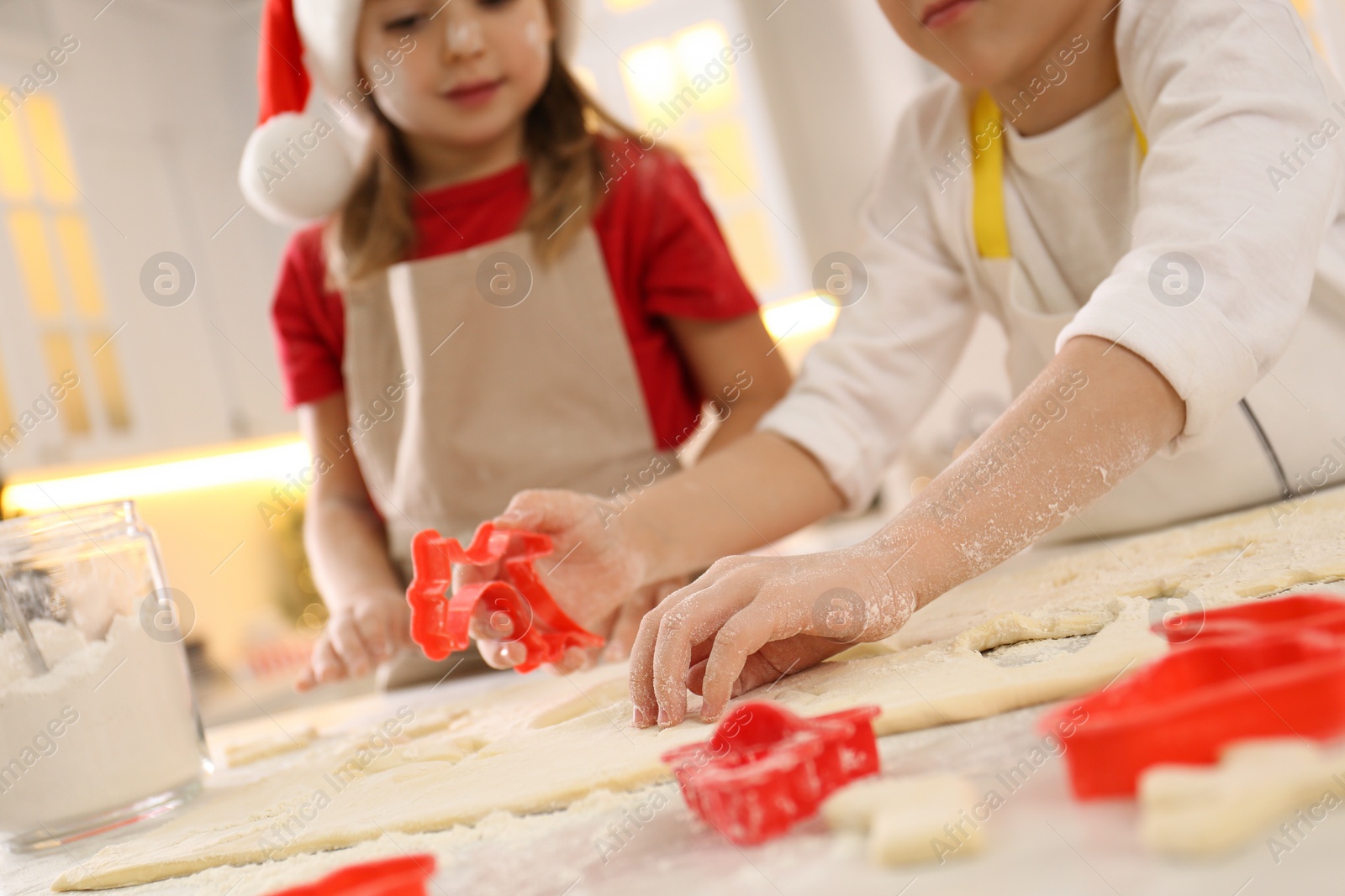 Photo of Little boy with his sister making Christmas cookies in kitchen, closeup