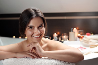 Photo of Happy beautiful woman taking bath indoors. Romantic atmosphere