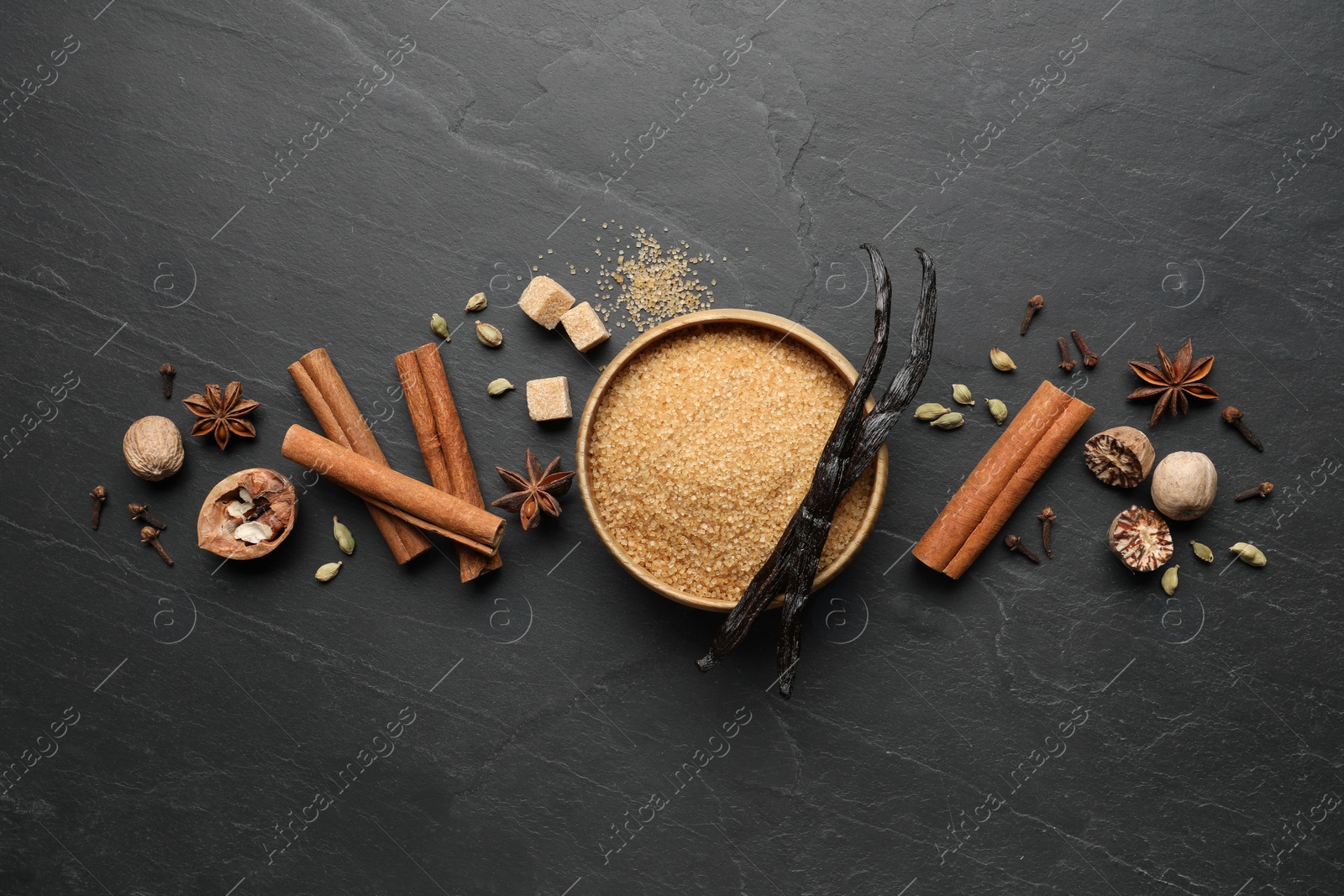 Photo of Different aromatic spices on dark textured table, flat lay