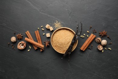 Photo of Different aromatic spices on dark textured table, flat lay