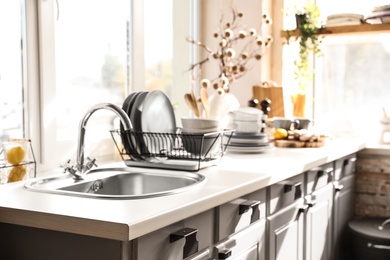 Stylish kitchen with sink and clean dishware