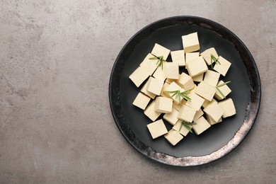 Delicious tofu with rosemary on grey table, top view. Space for text