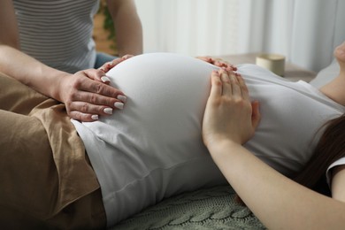 Photo of Doula taking care of pregnant woman indoors, closeup. Preparation for child birth
