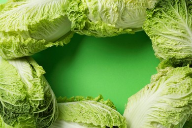 Photo of Frame with fresh ripe Chinese cabbages on light green background, flat lay. Space for text