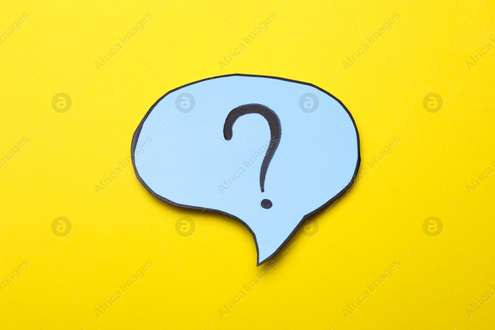 Photo of Paper speech bubble with question mark on yellow background, top view