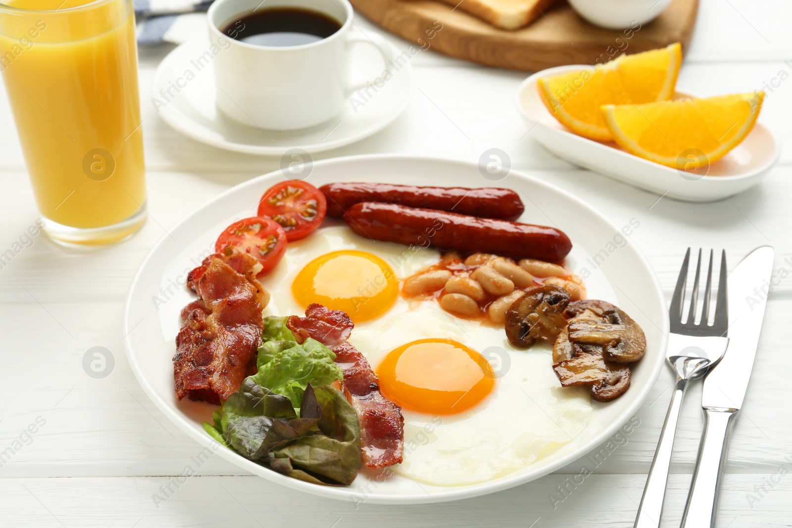 Photo of Delicious breakfast with sunny side up eggs served on white wooden table, closeup