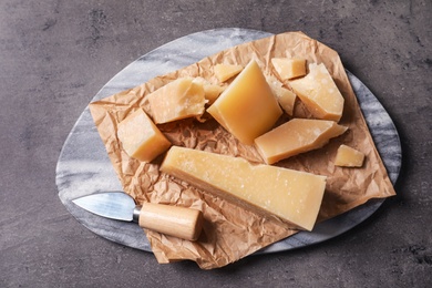 Photo of Marble board with delicious cheese on grey table, top view