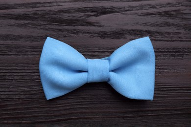 Photo of Stylish light blue bow tie on wooden table, top view