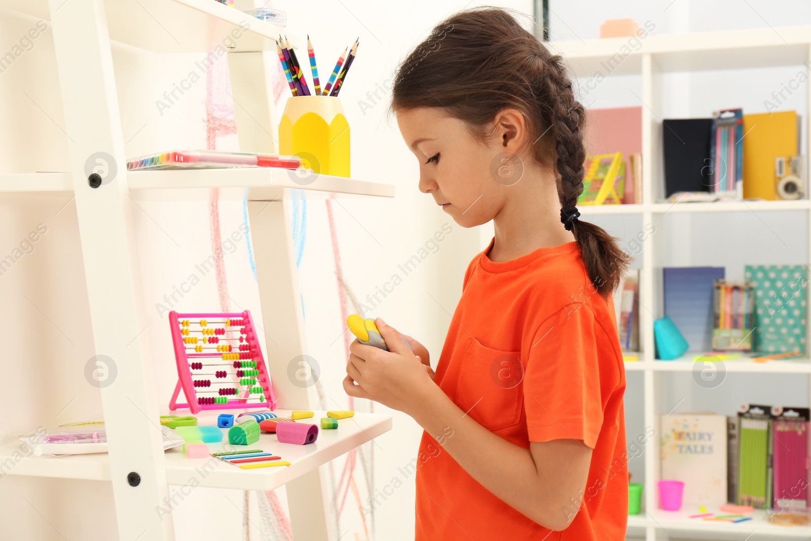 Photo of Cute child choosing school stationery in store