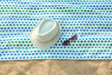 Photo of Bright beach accessories on sand, top view