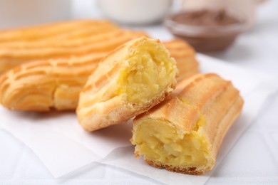 Photo of Delicious eclairs on white table, closeup view
