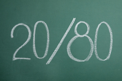 Photo of Numbers 20 and 80 written with chalk on green background. Pareto principle concept