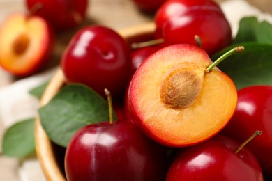 Photo of Delicious ripe cherry plums with leaves, closeup