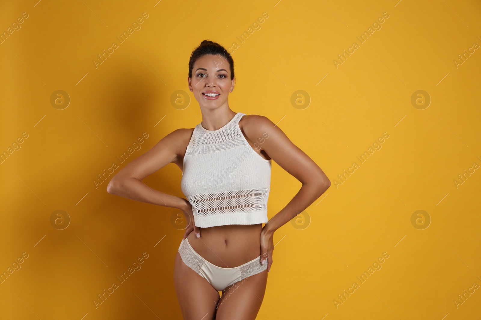 Photo of Beautiful woman in white sexy panties on yellow background