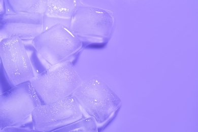 Melting ice cubes on color background, top view. Space for text