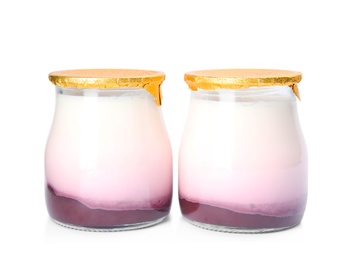 Photo of Glass jars of tasty fruit yogurt on white background